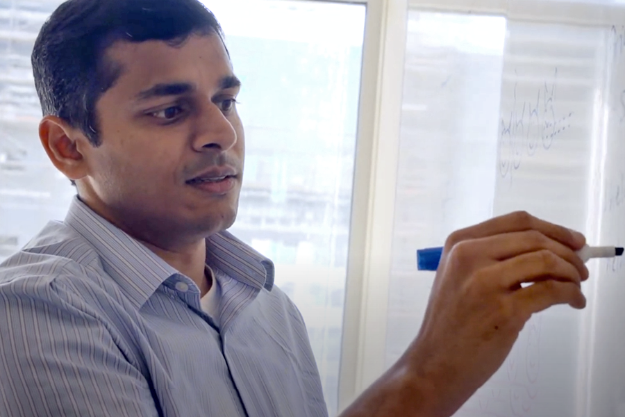 Vyas Sekar writing on a dry ease board.