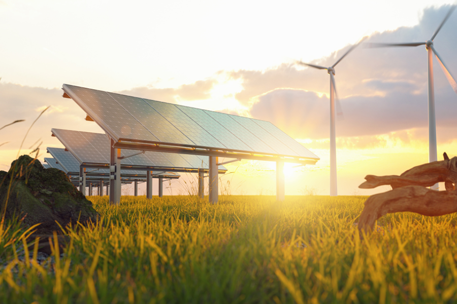 Sunset against solar panels and wind turbines