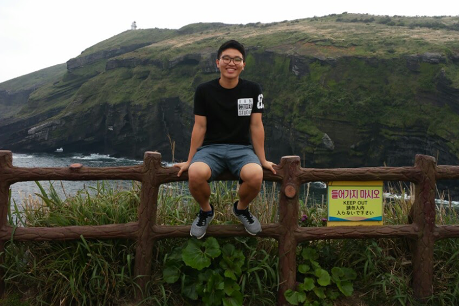 Junsu sitting on a fence