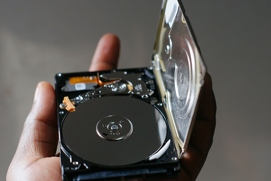 a hand holding a hard disk drive
