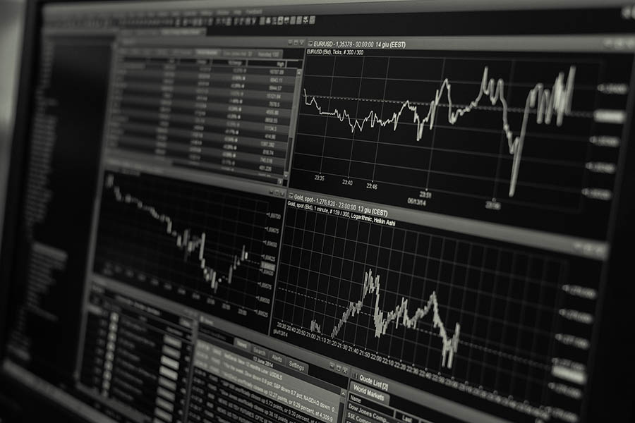 Computer screens with market trend graphs