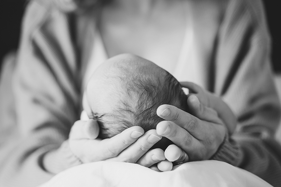 A black and white image of a mother holding a newborn baby.