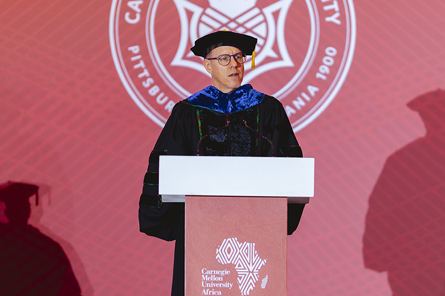 Tim Brown speaking at the podium during commencement